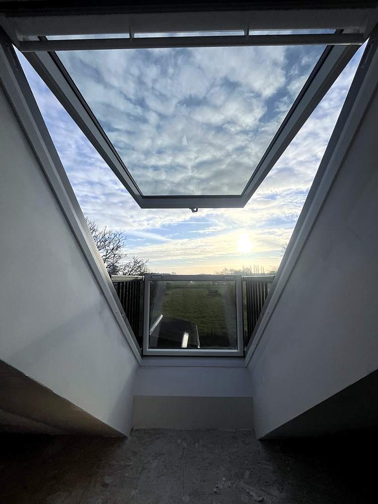 Nieuw dakraam met strak gepleisterde zolderwand